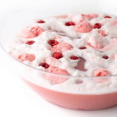 a bowl filled with ice cream and raspberries on top of a white table