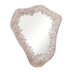 a mirror that is shaped like a heart with some rocks on the bottom and sides