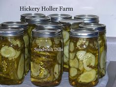 pickles in jars are sitting on a white tablecloth with the words hickery holler farm above them