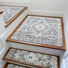 carpeted stair treads with wooden handrails and rugs on the bottom