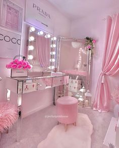 a pink room with vanity, stools and lights on the walls in front of it