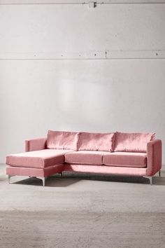 a pink couch sitting in front of a white wall