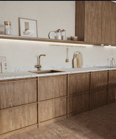 a kitchen with wooden cabinets and white counter tops, along with a gold faucet