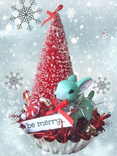 a small christmas tree with a bunny and candy canes in it, surrounded by snowflakes