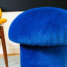 a blue ottoman sitting next to a yellow chair