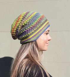 a woman with long hair wearing a multicolored knitted hat on her head