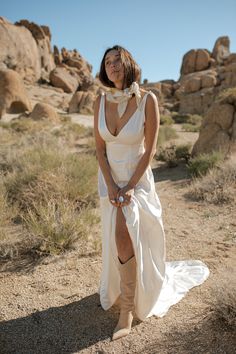 a woman in a white dress is standing on the ground with her legs spread out