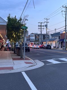 people are walking down the street at dusk