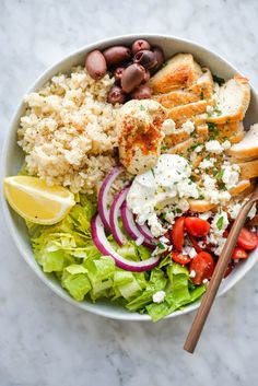 a white bowl filled with rice, meat and veggies