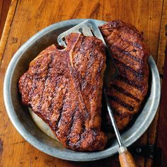 two steaks on a plate with a knife and fork