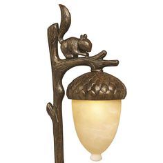 a lamp with a squirrel sitting on top of it's head hanging from a tree branch