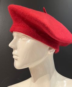 a white mannequin head wearing a red hat