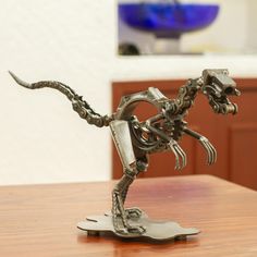 a metal sculpture of a skeleton on a wooden table