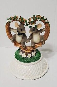 two little mice sitting on top of each other in the shape of a heart with flowers