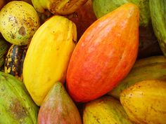 there are many different types of fruit in this pile together, including mangoes and papayas