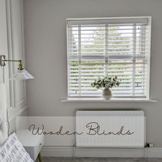 a white radiator sitting next to a window in a room with blinds on the windowsill