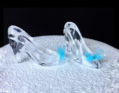 a pair of clear high heeled shoes sitting on top of a white cloth covered table