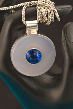 How about a gem inside a gem? This is the perfect layering necklace. Our one-of-a-kind Medallion pendant features a Portuguese cut blue quartz in the center of the Chalcedony stone. This is a bold piece of jewelry! The center bezel holding the Blue Quartz is handmade and welded to the Argentium silver back piece. This is totally 100% hand carved and handmade by us! We do not think we've seen the marriage of faceted gemstone & cabochons together in one piece before. This is totally 100% handmade Boho Necklace Layering, Back Piece, Green Amethyst Ring, Custom Wedding Band, Chalcedony Stone, Bold Jewelry, Jewelry Picture, Gemstone Cabochons, Medallion Necklace