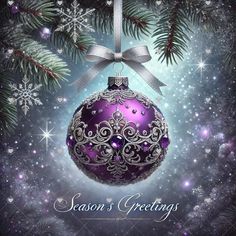 a purple christmas ornament hanging from a pine tree with snowflakes on it