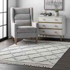 a white chair sitting on top of a wooden floor next to a dresser and window