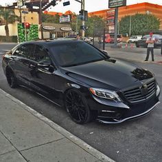 a black car is parked on the side of the street