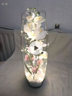 a glass vase filled with flowers on top of a white tablecloth covered bed next to a radiator