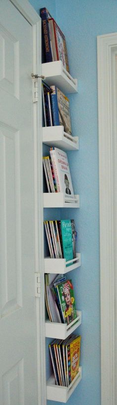 there is a book shelf in the corner of this room with blue walls and white doors