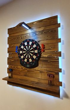 a dart board mounted to the side of a wooden wall with darts on it and an arrow in the center