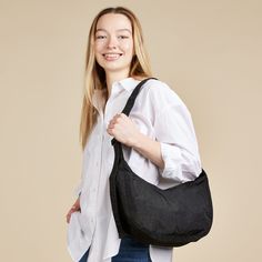 This effortlessly casual Baggu Crescent Bag is large enough to carry a bit more than just your daily essentials, making it a versatile go-to accessory. Made from durable 100% heavyweight nylon (59% recycled), this bag can be worn slung over your shoulder or crossbody for a hands-free experience. It features two interior pockets which make organizing your belongings easy. The Baggu Crescent Bag measures 8h x 13.75w x 4�d. The adjustable tonal logo strap is 37.5 at its maximum length. Machine wash Casual Nylon Hobo Bag For On-the-go, Functional Nylon Hobo Bag For Everyday Use, Functional Everyday Nylon Hobo Bag, Versatile Nylon Hobo Bag For On-the-go, Lightweight Nylon Shoulder Bag For Everyday Use, Reusable Nylon Bags For Everyday Use, Everyday Reusable Nylon Bags, Versatile Packable Black Shoulder Bag, Versatile Black Packable Shoulder Bag