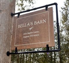 a wooden sign hanging from the side of a tree