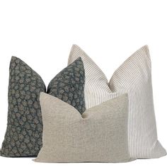 three pillows with different patterns on them sitting side by side in front of a white background