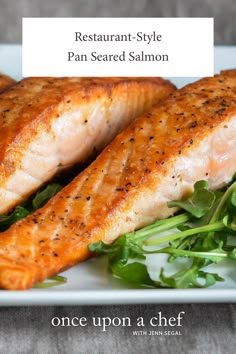 three salmon fillets on a plate with greens