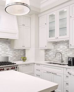 a kitchen with white cabinets and counter tops