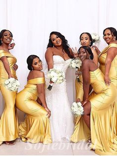 a group of women in yellow dresses posing for a photo with one woman wearing a white dress