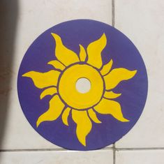 a yellow and blue sun painted on the side of a tile wall