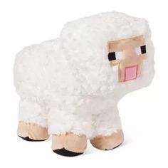 a stuffed sheep with a pink nose and black eyes on it's face is shown