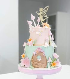 a cake decorated with flowers and fairy figurines