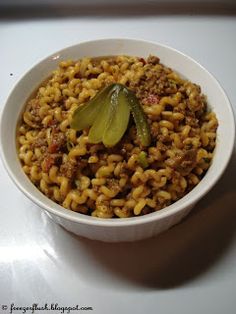 a white bowl filled with macaroni and cheese on top of a countertop