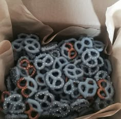 a box filled with lots of blue and orange pretzels on top of brown paper