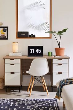 a white chair sitting in front of a desk with a clock on it