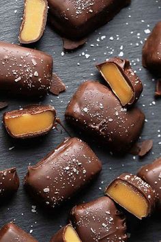 several pieces of chocolate covered in caramel and sea salt on top of a black surface