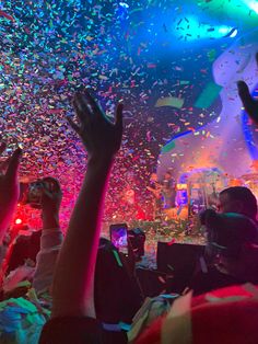 confetti falling from the ceiling at a party with people watching and taking pictures