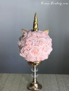 a vase with pink roses and a gold unicorn horn