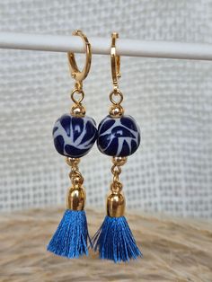 We combine art and elegance to create this beautiful piece. Our handmade earrings will be the perfect element to make your outfit standout. You could have the entire collection or gift them to someone special.  Material: Real Gold plate brass, Talavera gemstone  Dimensions: Drop Length 5cm, weight 2g Features : Lightweight, Unique and Simple design The Talavera of Puebla is part of the intangible heritage of humanity, declared by UNESCO. It is a type of majolica ceramic with a mixture of Chinese, Italian, Spanish, and indigenous techniques, and its colors are obtained from natural pigments. Its main characteristics are its vitreous finish and the use of bulky cobalt blue, this made it even more exclusive and ostentatious than Spanish craftsmanship. Its production requires at least 120 hour Artistic Gold Hoop Earrings As Gift, Artistic Gold Hoop Earrings For Gift, Beaded Dangle Earrings In Brass As A Gift, Dangle Beaded Brass Earrings For Gifts, Beaded Dangle Brass Earrings For Gifts, Gift Brass Beaded Dangle Earrings, Handmade Elegant Tassel Earrings As Gift, Elegant Handmade Adjustable Tassel Earrings, Traditional Nickel-free Beaded Earrings As Gift