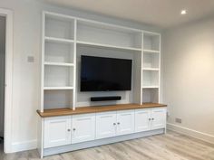 an entertainment center with built in cabinets and a flat screen tv mounted on the wall