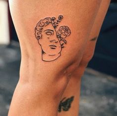 a woman's leg with a tattoo on it that has flowers in her hair