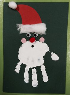 a handprint santa hat on top of a black paper with white snowflakes