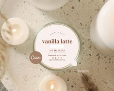 some candles are sitting on a table with the label vanilla latte next to them