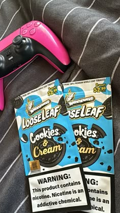 two packages of cookies and cream sitting on top of a bed next to a remote control