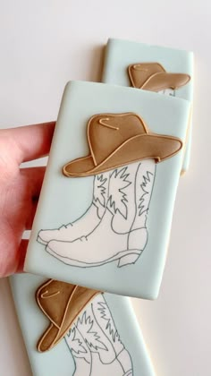 two handmade cookies with cowboy boots on them